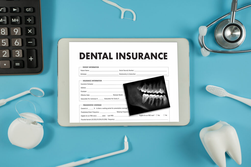 dental insurance form next to keyboard and dental instruments